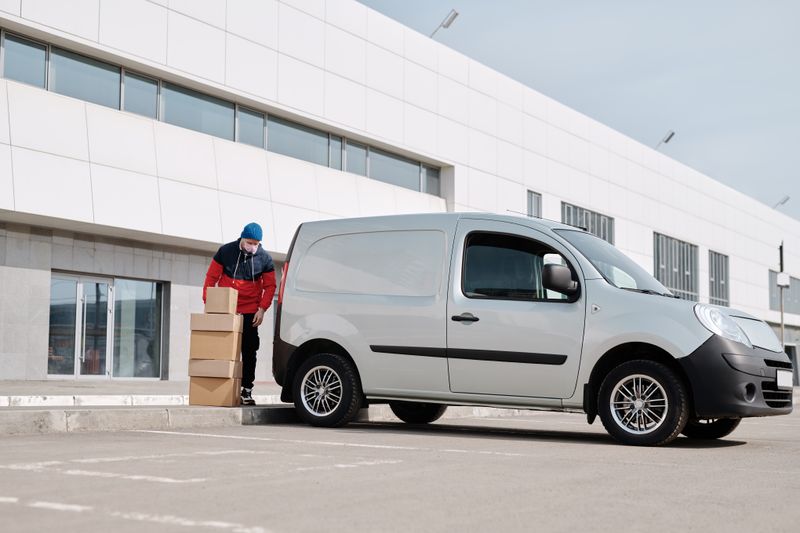 Delivery staff loading parcels beside a van